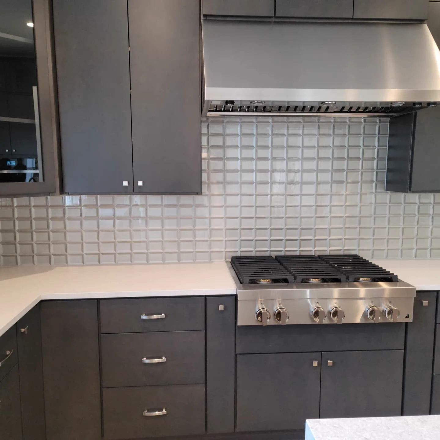 Kitchen with dark cabinetry and subway tile backsplash