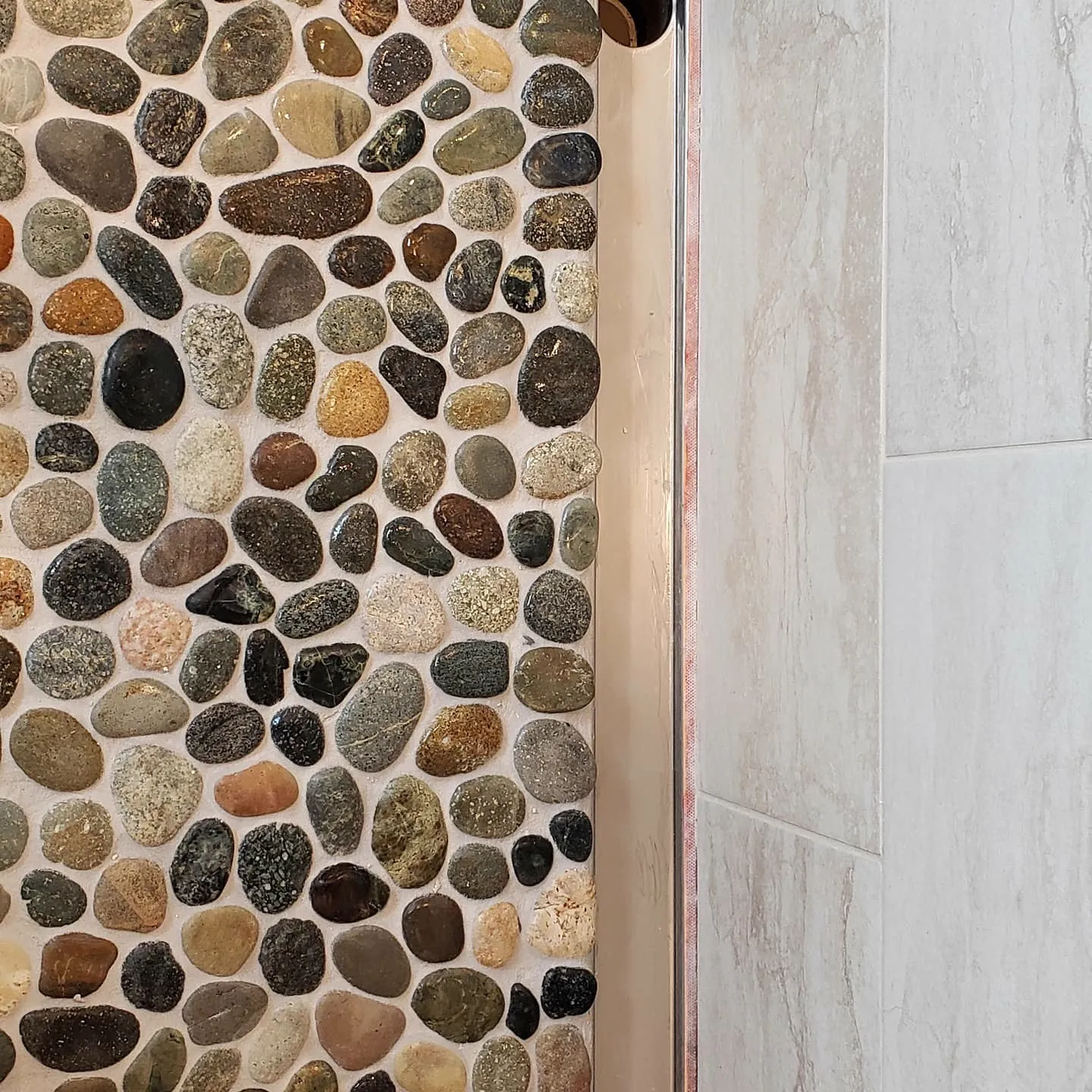 River rock accent wall at a shower entry