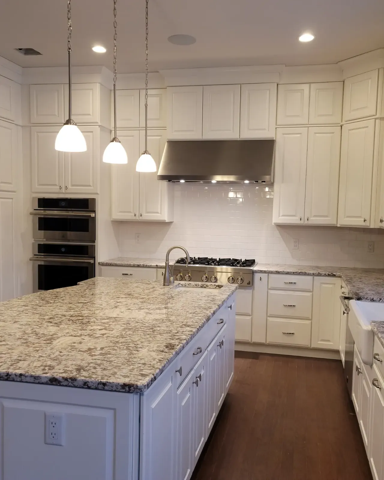 Kitchen island with pendant lighting and granite counters